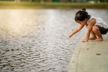 Wall Mural - Little girl playing at pond 