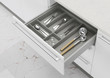 Open kitchen drawer with cooking utensils. Storage and organization of the kitchen. 3d rendering.