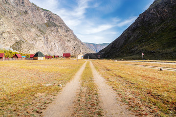 Wall Mural - Dirt road and camp site in the Chulyshman valley. Ulagansky District, Altai Republic, Russia