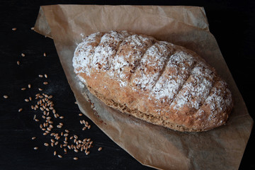 Freshly baked traditional bread sprinkled with flax seeds on parchment paper