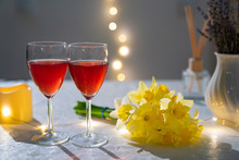 Glasses Red Wine On Table With Bouquet Daffodils