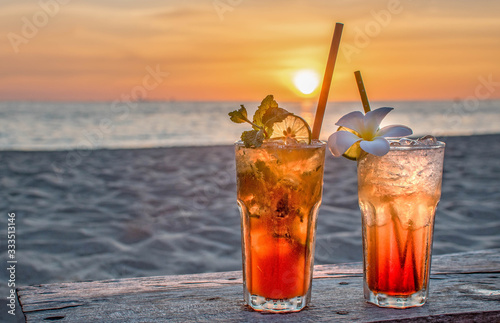drinks with blur beach and sunset in background Poster Mural XXL
