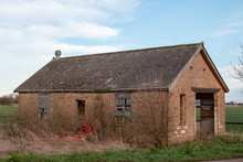 Old Abandoned Farm Building In Field