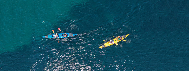 Wall Mural - Aerial drone ultra wide photo of young couple canoeing in tropical exotic island bay