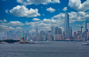 Fototapete - Statue of Liberty in New York Harbor with Manhattan skyline and Freedom Tower in background