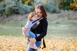 © kaloriya - Young mother carrying her baby in sling. Child with parent. Cute toddler girl in carrier. Attachment parenting concept.