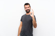 © luismolinero - Young handsome man over isolated white background showing ok sign with fingers