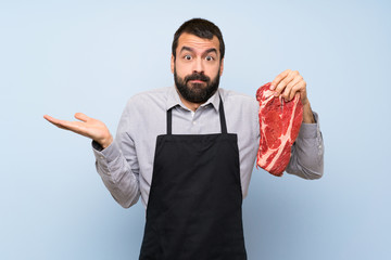 Wall Mural - Chef holding a raw meat having doubts while raising hands