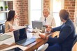 © Krakenimages.com - Group of business workers working together. Sitting on desk using laptop reading documents at the office