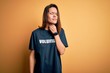 © Krakenimages.com - Young beautiful brunette girl doing volunteering wearing t-shirt with volunteer message word Touching painful neck, sore throat for flu, clod and infection