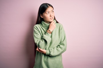 Sticker - Young beautiful asian woman wearing green winter sweater over pink solated background Thinking worried about a question, concerned and nervous with hand on chin