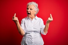 Senior Beautiful Woman Wearing Elegant Shirt Standing Over Isolated Red Background Showing Middle Finger Doing Fuck You Bad Expression, Provocation And Rude Attitude. Screaming Excited