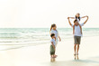 © CandyRetriever  - Happy Young Asian happy family parents with child walking and having fun together on the beach at sunset in summertime. Father, mother and kids relax and enjoy summer lifestyle travel holiday vacation