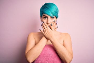 Sticker - Young woman with blue fashion hair wearing towel after shower over pink background shocked covering mouth with hands for mistake. Secret concept.