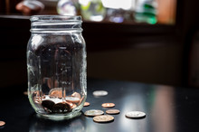 Glass Tip Jar Partly Full Of Loose Coin Change
