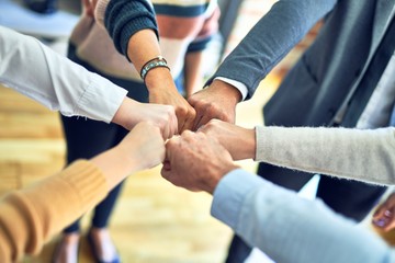 Wall Mural - Group of business workers standing bumping fists at the office