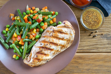 Wall Mural - grilled chicken fillet with steamed vegetables and sauce