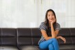 © siraphol - Portrait beautiful young asian woman happy smile relax on sofa in living room