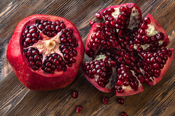 Two peeled pomegranates on wooden table