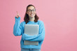 © Martin Villadsen - Smart looking student on colorful background holding her finger up to signal that she have an good idea