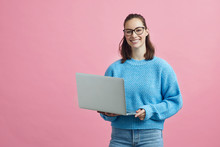 Portrait Of Smart Looking Student With Glasses, Holding Her Laptop
