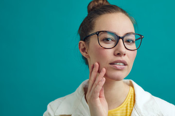 Wall Mural - Beautiful girl looking into the camera / mirror to se her new look with glasses