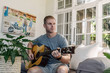 © Tyler - Man playing guitar at home during COVID-19 Lockdown