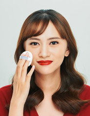 Sticker - Makeup beauty Asian woman applying powder foundation on face.