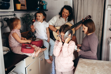 Wall Mural - large family with 4 children plays music at home