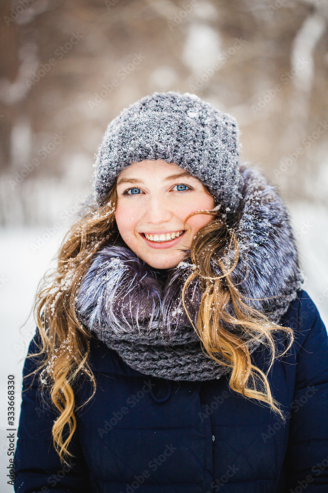 A girl of European appearance walks in the Park, forest, winter and snow, dressed in warm clothes, hat, jacket, scarf, rest, Hiking