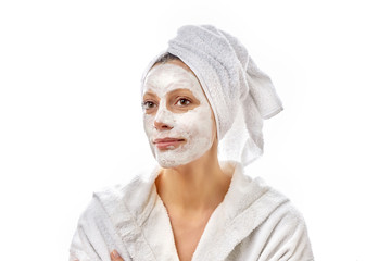 Beautiful young happy girl with a cloth mask.on her face smiles and enjoys the spa day.