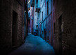 An atmospheric, narrow, back alley painted with blue and magenta light taken in Recanati, Macerata, Italy