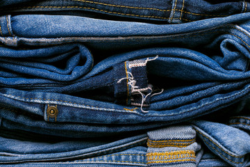 Wall Mural - Stack of jeans on a concrete background. Selvedge jeans. Copy space.