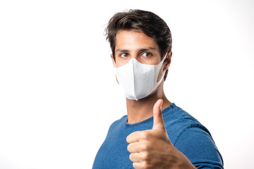 Handsome man brazilian showing okay gesture. Photo of healthy man wears protective mask against infectious diseases and flu. Health care concept.Mask prevent Covid 19 OK Leave space White background