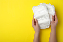 Woman With Diapers On Yellow Background, Closeup. Space For Text