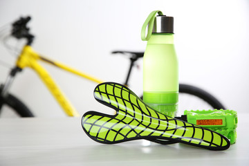 Sticker - Bicycle saddle, bottle and pedals on white table. Space for text