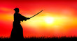 Japanese warrior samurai with a sword at sunset. A man stands with a sword in his hands against the backdrop of a sunny sunset