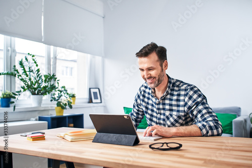 Photographie Freelancer working from home sitting at desk with digital tablet
