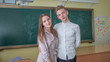 © Довидович Михаил - Senior students guy and girl on the background of the school blackboard.