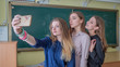 © Довидович Михаил - Beautiful schoolgirls take pictures of themselves in the classroom.