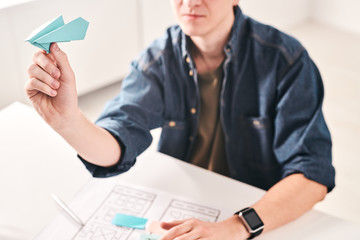 Aufkleber - Close-up of young man sitting at table and throwing paper plane while working on UI design in office