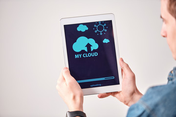 Aufkleber - Over shoulder view of young man using digital tablet while uploading files on cloud service