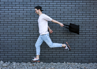 Wall Mural - fashion guy run over brick black urban background