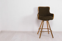 Green Bar Stool With Soft Upholstery And Gold Legs On A White Background