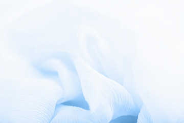 Pale blue and white corrugated flowing silk fabric background