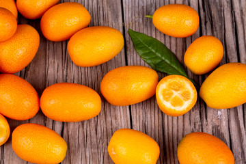 Wall Mural - Top view of bunch of fresh kumquats in the organic food market. Some kumquats is cutted.