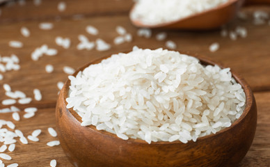 Poster - rice grains in bowl on wooden background