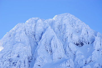 Bucura II Peak, 2372m. Winter alpine landscape in National Park Retezat, Carpathians, Romania, Europe. Snow covered moutains scenery