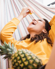 Mujer comiendo fruta en una hamaca