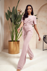 Wall Mural - Beautiful sexy brunette woman tanned skin face cosmetic makeup wear pink suit pants for date walk office fashion clothes style collection interior room sand color safari summer armchair palm boho.